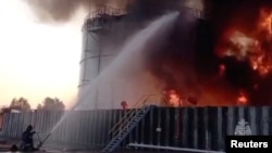 Ruski vatrogasci se bore sa požarom u rezerovaru za naftu koji je navodno izazvan napadom dronom, u gradu Azov, u Rostovu, Rusija, 18. juna 2024. (Foto: Reuters/Ministarstvo Rusije za vanredne situacije)