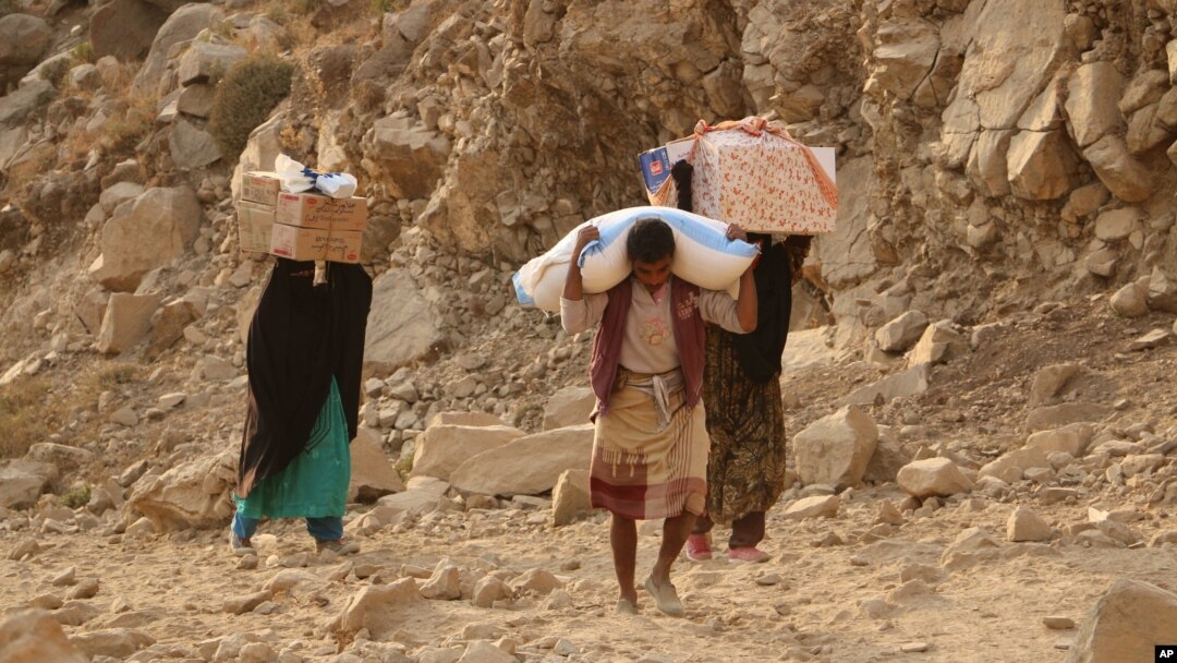 Warga Yaman membawa bantuan makanan yang disalurkan WFP di kota Taiz.