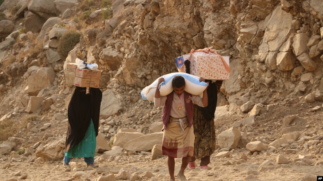 Warga Yaman membawa bantuan kemanusiaan di luar kota Taiz, Yaman, 17 Januari 2016.