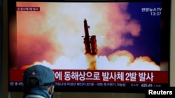 FILE - A man watches a TV broadcast showing a file photo for a news report on North Korea firing two unidentified projectiles, in Seoul, South Korea, March 2, 2020. 