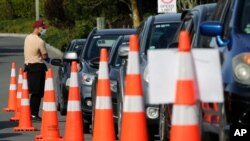 FILE - Motorists wait to take a COVID-19 test at a drive through community based assessment centre in Christchurch, New Zealand, Aug. 13, 2020. 