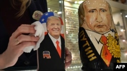 An employee polishes traditional Russian wooden nesting dolls depicting Donald Trump (L), U.S. president-elect at the time, and Russian President Vladimir Putin at a gift shop in central Moscow, Russia, Jan. 16, 2017.