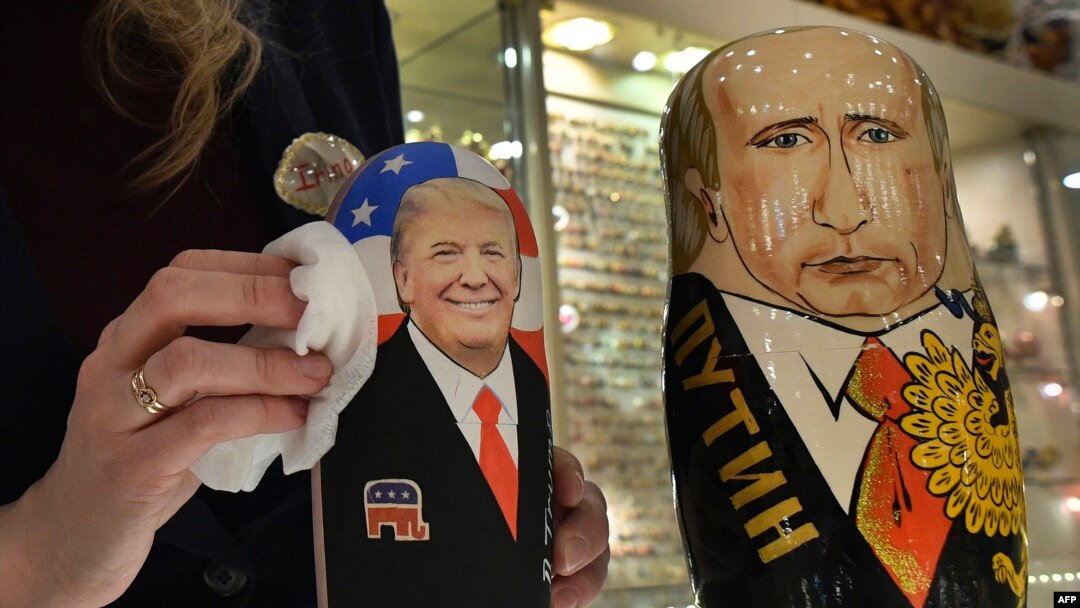 Prodavačica čisti tradicionalne ruske drvene lutke "babuške" sa likovima u to vreme američkog novoizabranog predsednika Donalda Trampa i ruskog predsednika Vladimira Putina u prodavnici suvenira u Moksvi, Rusija, 16. januar 2017. (FP PHOTO / Alexander NEMENOV)