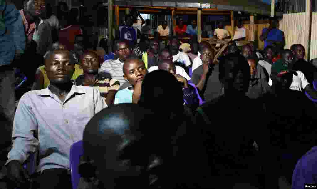 Residents watch the tallying of cast votes on television during presidential and parliamentary elections in the western town of Kisumu, 350 km (218 miles) from the capital Nairobi, March 5, 2013. 