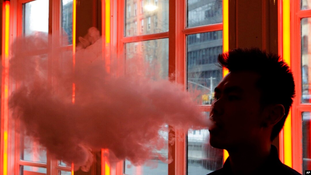 FILE - A patron exhales vapor from an e-cigarette at the Henley Vaporium in New York