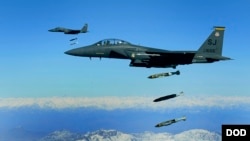 FILE - U.S. Air Force F-15E Strike Eagle aircraft from the 335th Fighter Squadron drop 2,000-pound joint direct attack munitions on a cave in eastern Afghanistan, Nov. 26, 2009.