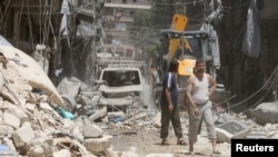 Residents inspect a damaged site after an airstrike on Aleppo's rebel held Al-Mashad neighbourhood, Syria, July 26, 2016. 