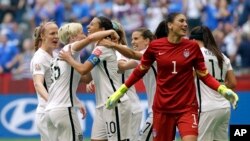 United States' Carli Lloyd (3-L) celebrates with teammates, including goalkeeper Hope Solo (1), after Lloyd scored her third goal against Japan during the first half of the Women's World Cup soccer championship in Vancouver, Canada, July 5, 2015.