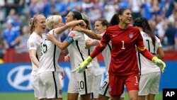 United States' Carli Lloyd (3-L) celebrates with teammates, including goalkeeper Hope Solo (1), after Lloyd scored her third goal against Japan during the first half of the Women's World Cup soccer championship in Vancouver, Canada, July 5, 2015. (AP Photo/Elaine Thompson)