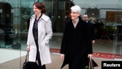 Head of the U.S. delegation, Under Secretary of State Wendy Sherman (R), and an unidentified person leave a hotel in Vienna, Feb. 17, 2014.