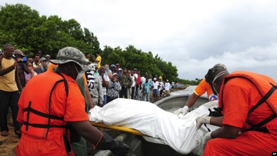 Relatives of passengers of an immigrant boat that capsized last Saturday watch as rescue workers arrive at the beach with more bodies they picked up in the ocean, in Sabana de La Mar February 8, 2012.