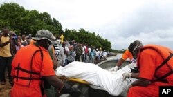 Relatives of passengers of an immigrant boat that capsized last Saturday watch as rescue workers arrive at the beach with more bodies they picked up in the ocean, in Sabana de La Mar February 8, 2012.