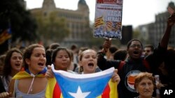 People wearing yellow ribbons in support of jailed pro-independence politicians and carrying Estelada pro-independence flags protest in Barcelona, Spain, Oct. 14, 2019.