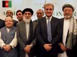 Afghan politicians and other participants pose with Pakistani Foreign Minister Shah Mahmood Qureshi, second right, after the opening session of an Afghan Peace Conference in Bhurban, Pakistan, June 22, 2019.