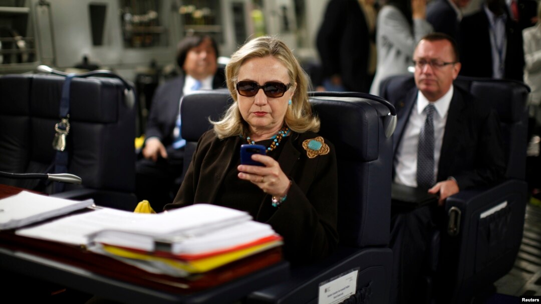 Hillary Clinton memeriksa ponselnya dalam perjalanan dinasnya sebagai Menlu AS dari Malta ke Libya tahun 2011 (foto: dok).
