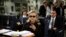 FILE - Then US secretary of state Hillary Clinton checks her mobile phone upon her departure in a military C-17 plane from Malta bound for Tripoli,  Libya, Oct. 18, 2011.