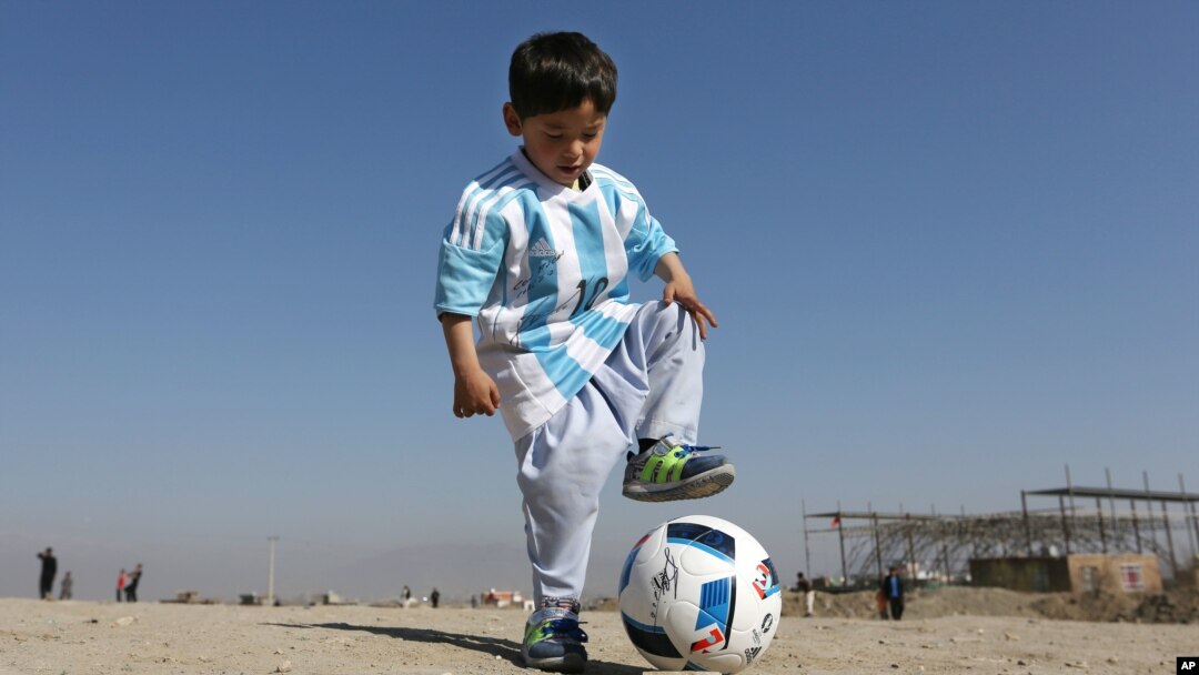 Murtaza Ahmadi, anak Afghanistan berusia lima tahun dengan seragam sepakbola yang ditandatangani Lionel Messi.