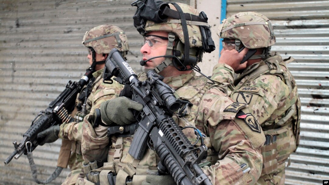 U.S. soldiers stand guard at the scene of a suicide attack in Kabul, Afghanistan, Feb. 27, 2013.