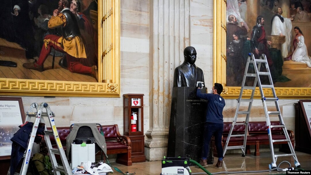 Gompo Yarmolinsky with the Architect of the Capitol cleans the bust of Martin Luther King Jr. in the Capitol Rotunda after supporters of U.S. President Donald Trump stormed the U.S. Capitol in Washington, January 12, 2021. 