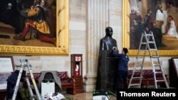 Gompo Yarmolinsky with the Architect of the Capitol cleans the bust of Martin Luther King Jr. in the Capitol Rotunda after supporters of U.S. President Donald Trump stormed the U.S. Capitol in Washington, January 12, 2021. 