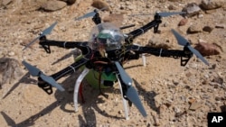 Six-bladed drone casts shadow on a heavily looted 5,000-year-old cemetery, known as Fifa, in southern Jordan, March 19, 2015.