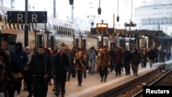 ຄົນ​ໂດຍ​ສານ​ຍ່າງ​ຜ່ານ​ບ່ອນ​ລໍ​ຖ້າ​ລົດ​ໄຟ​ໃນ​ສະຖາ​ນີ​ລົດ​ໄຟ Gare de Lyon ໃນ​ປາ​ຣີ Paris ໃນ​ຂະ​ນ​ະ​ທີ່​ພະ​ນັກ​ງານ​ລົດ​ໄຟ (SNCF) ແລະພະ​ນັກ​ງານ​ດ້ານ​ການ​ຂົນ​ສົ່ງ​ຂອງ​ຝ​ຣັ່ງສືບ​ຕໍ່​ປະ​ທ້ວງແຜນການ​ປະ​ຕິ​ຮູບລະ​ບົບ​ເບ້ຍ​ບຳ​ນານຂອງ​ຝ​ຣັ່ງ ຢູ່​ນັ້ນ ໃນ​ວັນ​ທີ 6 ທັນ​ວາ, 2019