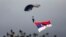 FILE - A Serbian army paratrooper descends with a giant Serbian flag during a military parade in Belgrade, Serbia, Oct. 16, 2014.