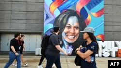 People walk by a mural of Democratic presidential nominee Vice President Kamala Harris outside the United Center ahead of the Democratic National Convention (DNC) in Chicago, Illinois on August 17, 2024.