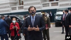 Con una máscara en medio de la pandemia de COVID-19, el presidente peruano, Martín Vizcarra, habla con los reporteros después de salir del Congreso en Lima, Perú, el lunes 9 de noviembre de 2020.