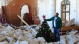 A man sets up a Christmas tree amidst the rubble of the Melkite Church, which was hit by an Israeli airstrike on Oct. 9, in the southern Lebanese village of Derdghaya on Dec. 20, 2024.