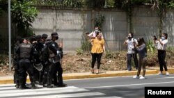 Policías nicaragüenses bloquean a periodistas que filmaban frente a la casa de la líder opositora Cristiana Chamorro luego de que fiscales buscaran su arresto por lavado de dinero y otros delitos, según autoridades judiciales, en Managua, Nicaragua, el 2 de junio de 2021.