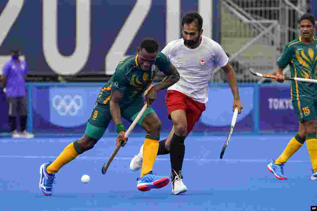 South Africa&#39;s Nduduza Peabo Lembethe (8) drives the ball against Canada&#39;s Keegan Reginald Pereira, center right, during a men&#39;s field hockey match at the 2020 Summer Olympics, Friday, July 30, 2021, in Tokyo, Japan. (AP Photo/John Minchillo)