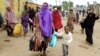 Somali families move out of their homes after they were broken into during the second day of skirmishes in the Eastleigh neighborhood of Kenya's capital Nairobi, Nov. 19, 2012. 