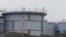 FILE - Workers wearing protective gears stand on the water tank that stores contaminated water at the Fukushima Dai-ichi nuclear power plant in Okuma, Fukushima prefecture, northeastern Japan, Nov. 12, 2014. 