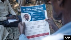 A man holds a flyer printed by the International Criminal Court (ICC) explaining the trial of LRA commander Dominic Ongwen, in Lukodi, Uganda, Feb. 4, 2021.