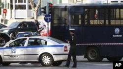 A police car blocks the road that connects to the Justice Ministry in Athens, Feb 2, 2011
