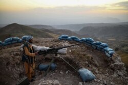 In this picture taken on July 11, 2021 an Afghan militia fighter keeps a watch at an outpost against Taliban insurgents at Charkint district in Balkh Province.