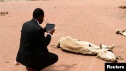 An aid worker using an iPad films the rotting carcass of a cow in Wajir near the Kenya-Somalia border, July 23, 2011.