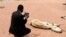 An aid worker using an iPad films the rotting carcass of a cow in Wajir near the Kenya-Somalia border, July 23, 2011.
