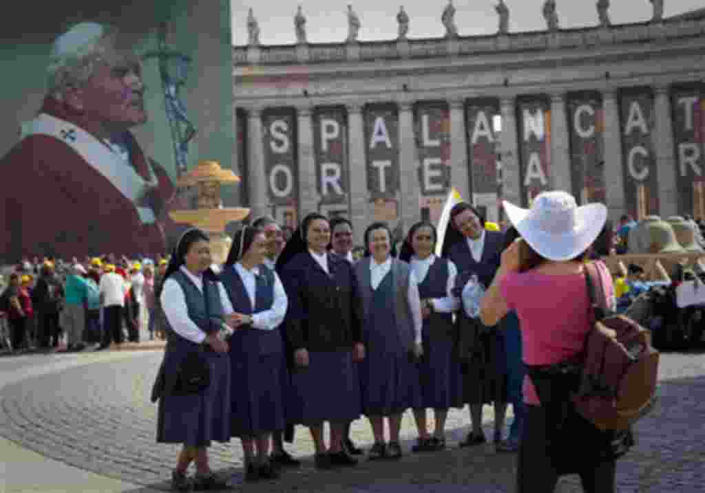 Un grupo de monjas posan delante de la imagen del papa Juan Pablo II.