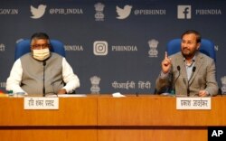 FILE - In this Feb. 25, 2021, photo, India's Information Technology Minister Ravi Shankar Prasad, left, and Information and Broadcasting Minister Prakash Javadekar new regulations for social media companies and digital streaming websites.