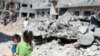 A Palestinian girl carries a boy amid the rubble of their houses which were destroyed by Israeli air strikes during the Israel-Hamas fighting in Gaza, May 23, 2021. 