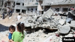 一对巴勒斯坦儿童在被摧毁的住房前。