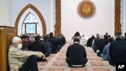 Muslim Bosnia, beberapa memakai masker wajah untuk melindungi diri dari infeksi Covid-19, menghadiri sholat Idul Fitri di Sarajevo, Bosnia, Minggu, 24 Mei 2020. (Foto: AP)