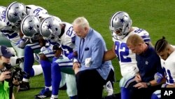 FILE - The Dallas Cowboys, led by owner Jerry Jones, center, take a knee before the national anthem at an NFL football game against the Arizona Cardinals, in Glendale, Ariz., Sept. 25, 2017.