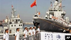 中国海军官兵站在青岛号导弹驱逐舰上（右）准备去参加中美海军联合演习(2013年8月20日)