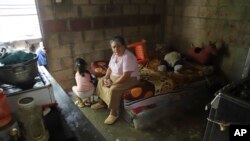 Jesús Esperanza Ventura, que ayuda en el cuidado de sus bisnietos, sentada en la cama de su nieta, Juana Guadalupe Recinos, en Santa Ana, El Salvador, el 31 de enero de 2024