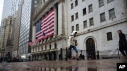 19일 마스크를 쓴 행인이 뉴욕 증권거래소 앞을 지나가고 있다.