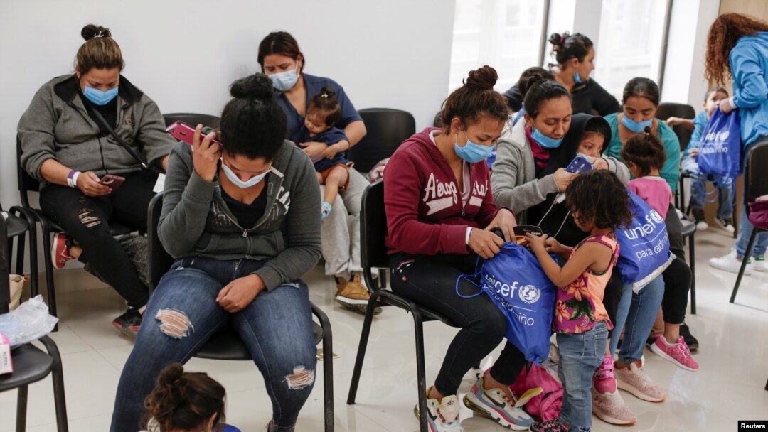 FILE - Asylum-seeking migrants from Central America, who were airlifted from Brownsville to El Paso, Texas, and deported from the U.S., wait inside the office of the Center for Integral Attention to Migrants in Ciudad Juarez, Mexico, March 16, 2021.