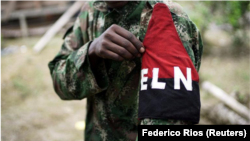 Un miembro del Ejército de Liberación Nacional (ELN) de Colombia muestra un emblema al posar para una fotografía en las selvas del noroeste del país, en Colombia, el 31 de agosto de 2017.